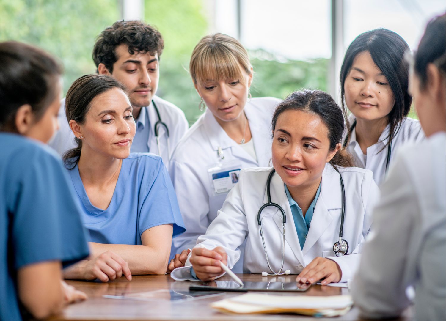 A group of medical professionals in uniforms and scrubs having a conversation.